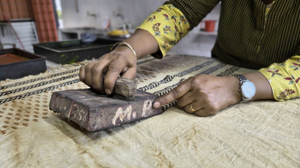 Artisan hand block printing on cotton fabric during a traditional Bagru workshop near Jaipur