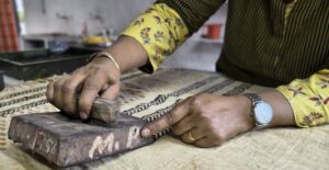 Artisan hand block printing on cotton fabric during a traditional Bagru workshop near Jaipur